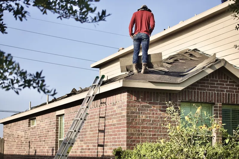 Professional roofer working on a residential roof in Priceville